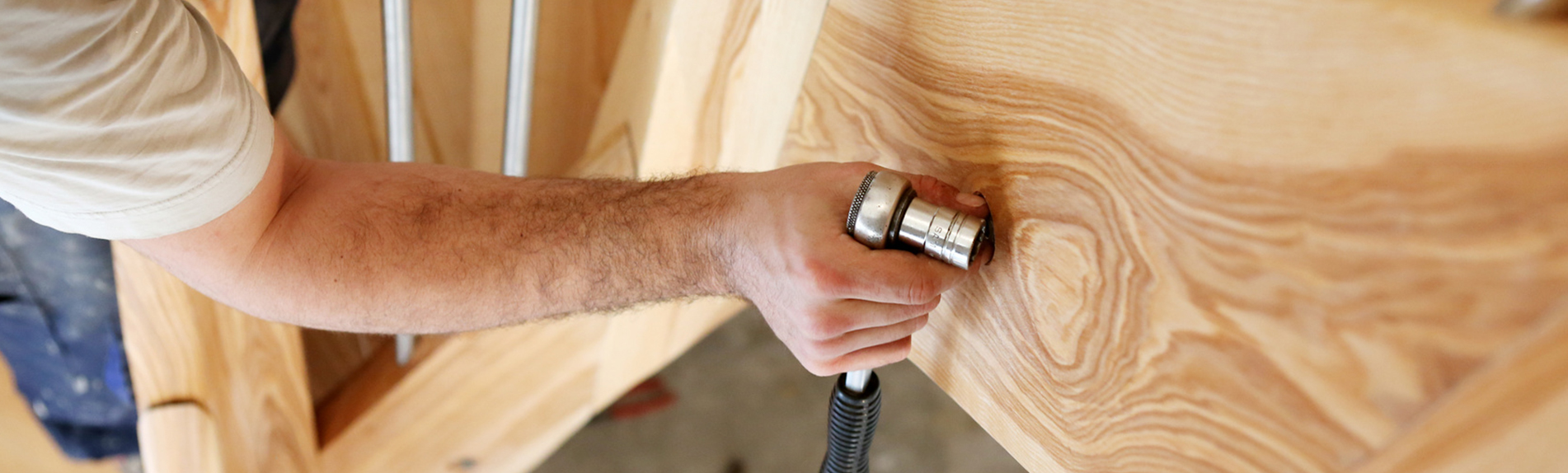 Un artisan utilise une fraiseuse pour travailler un panneau de bois massif